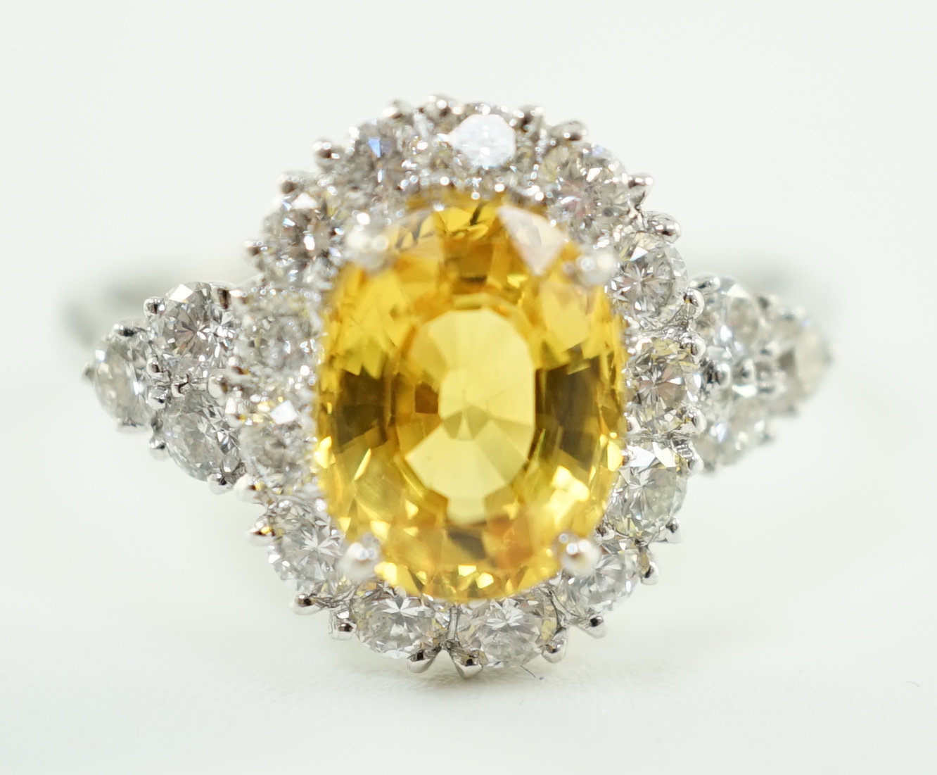 A modern 18ct white gold and single oval cut yellow sapphire set ring